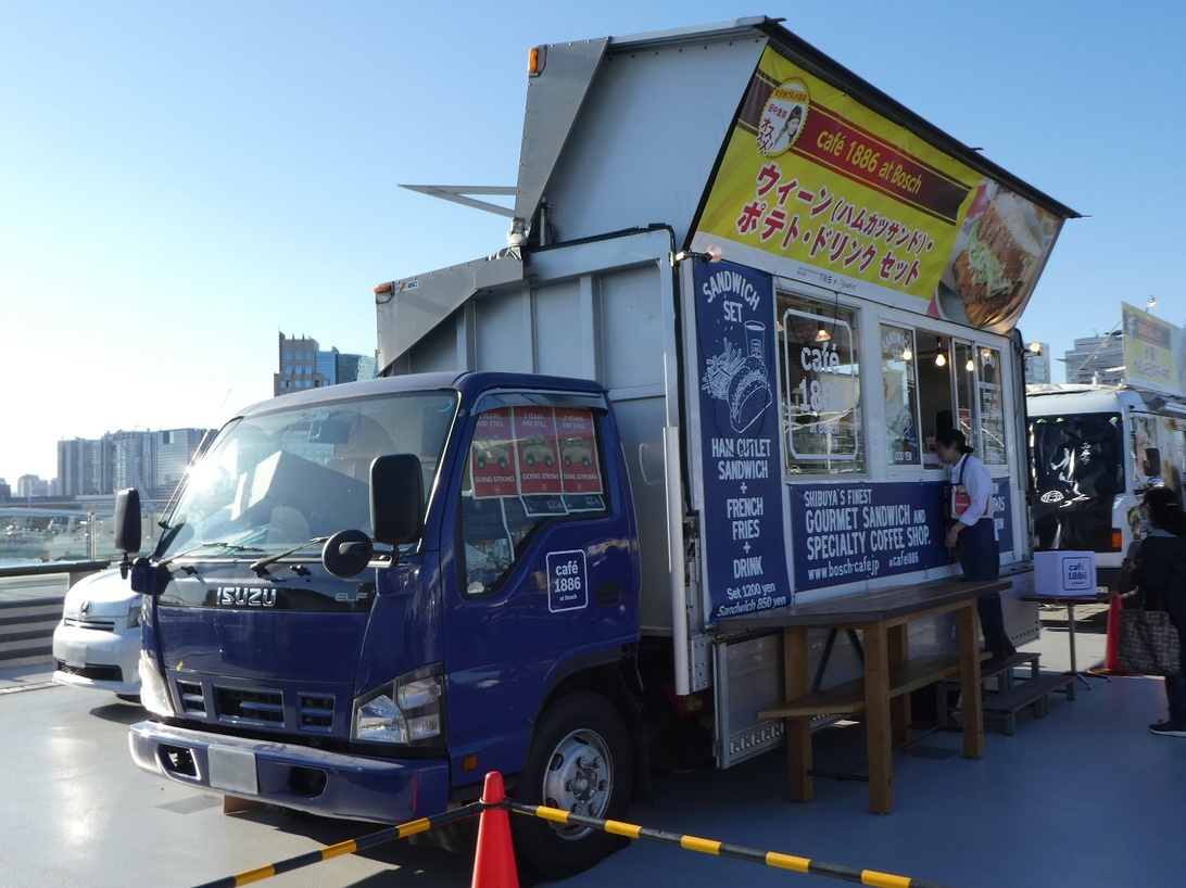 Een moderne foodtruck met zonnepanelen op het dak op een festival.